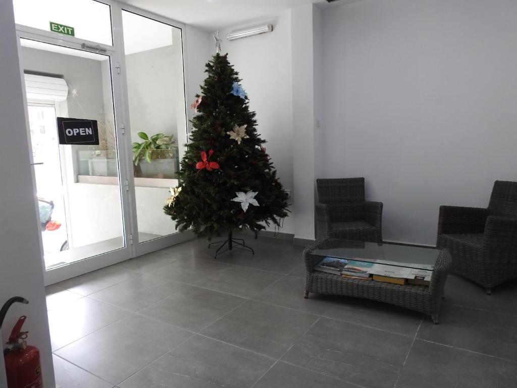 a christmas tree in a living room with a table at Magnolia Guest House in St. Julianʼs