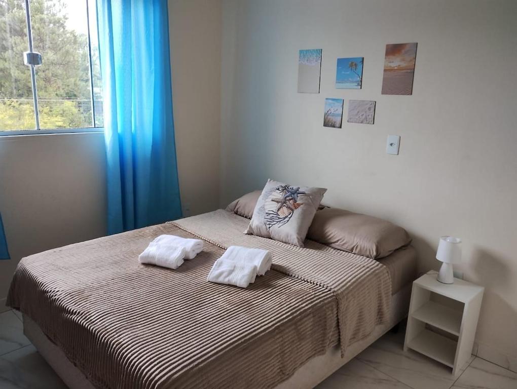 une chambre avec un lit avec deux serviettes dessus dans l'établissement Apartamento Praia do Sonho- CasaMora, à Palhoça