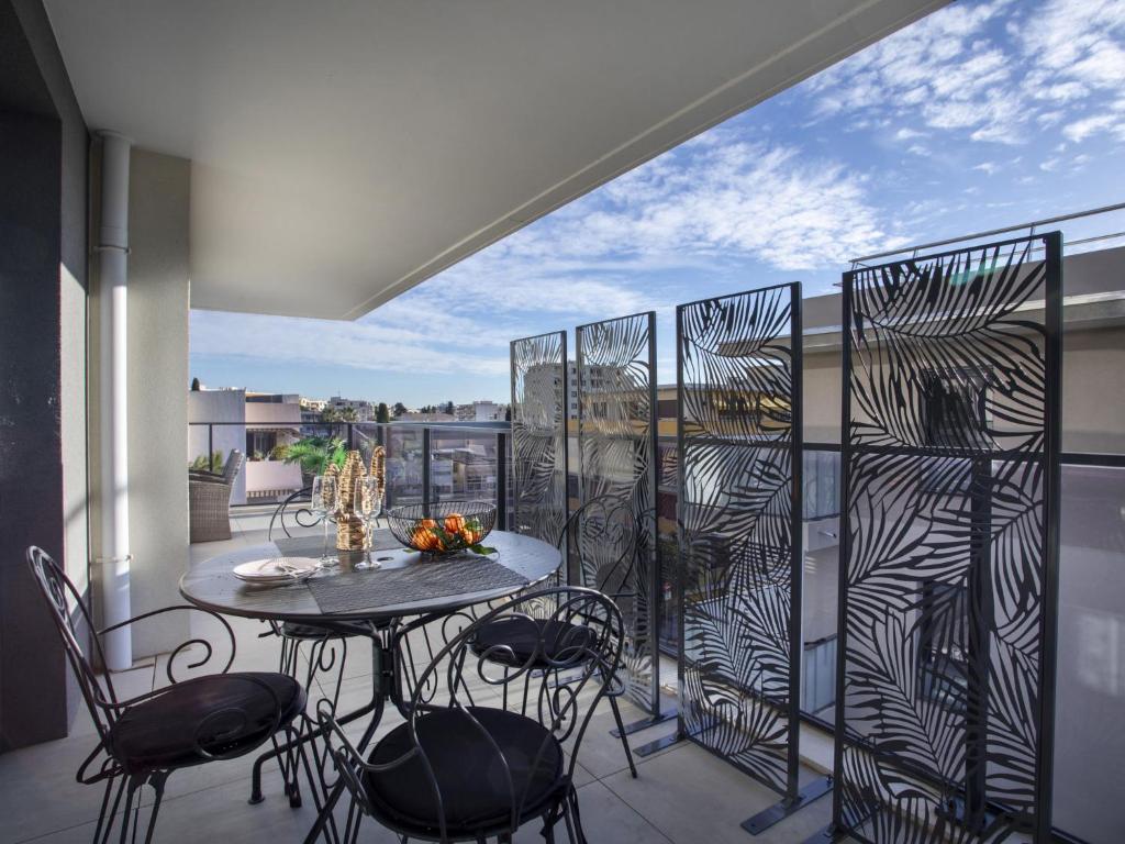 un patio avec une table et des chaises sur un balcon dans l'établissement Apartment Le Grey Pearl by Interhome, à Cagnes-sur-Mer