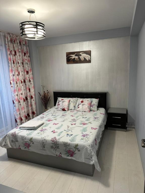 Un dormitorio con una cama con una colcha floral. en Felicity 1, en Craiova