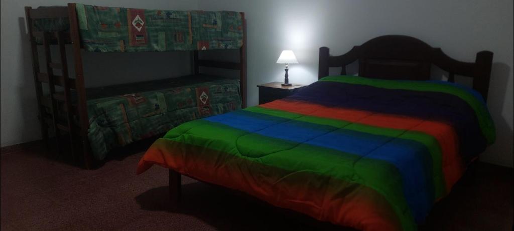 a bedroom with a rainbow colored bed with a canopy at La casa de Los Patitos in Arroyo de Los Patos