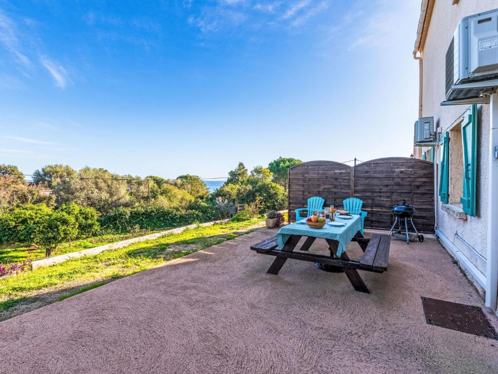 un patio con una mesa y dos sillas azules en Apartment T2 Gabriello by Interhome, en Cala dʼOro