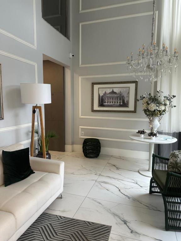 a living room with a white couch and a table at Apto sacada vista mar navegantes in Navegantes