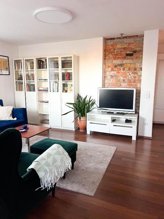 a living room with a couch and a tv at GreenHill House in Kaunas