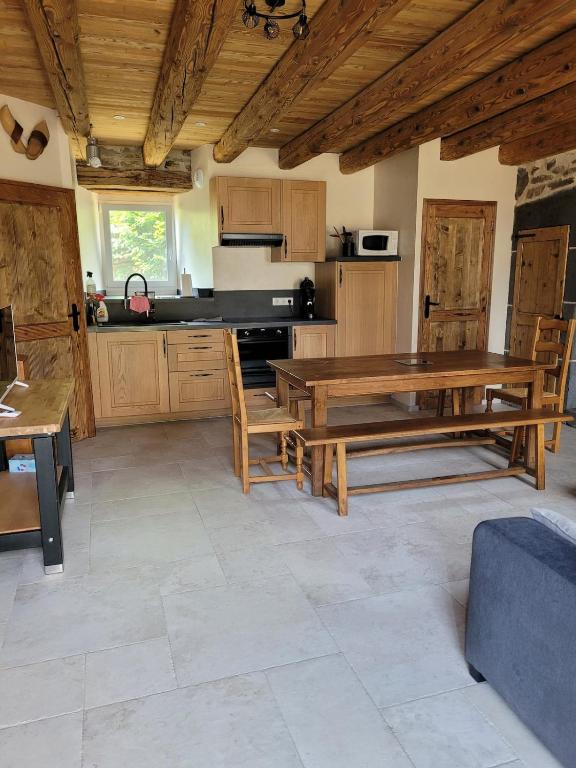 a kitchen with wooden furniture and a table in it at Maison 4 à 9 personnes à la campagne in Alleuze