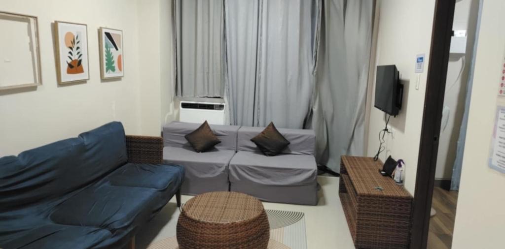 Una sala de estar con un sofá azul y un televisor en Relax in Paradise Boracay Island, en Boracay