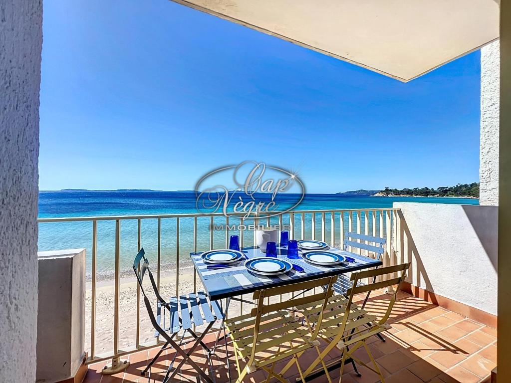 - une table sur un balcon avec vue sur l'océan dans l'établissement Appartement T2 vue mer, pieds dans l'eau avec accès direct à la plage de Cavalière - LE LAVANDOU, au Lavandou