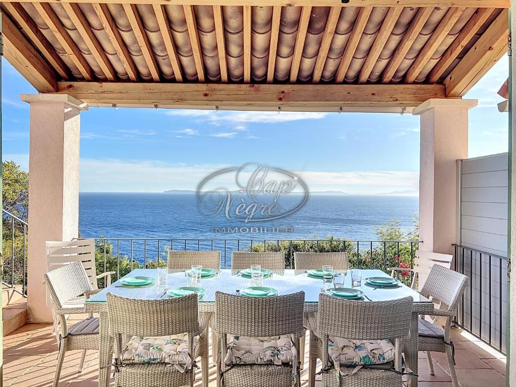 - une table et des chaises sur une terrasse donnant sur l'océan dans l'établissement Maison vue mer pour 8 personnes au Rayol, à Rayol-Canadel-sur-Mer