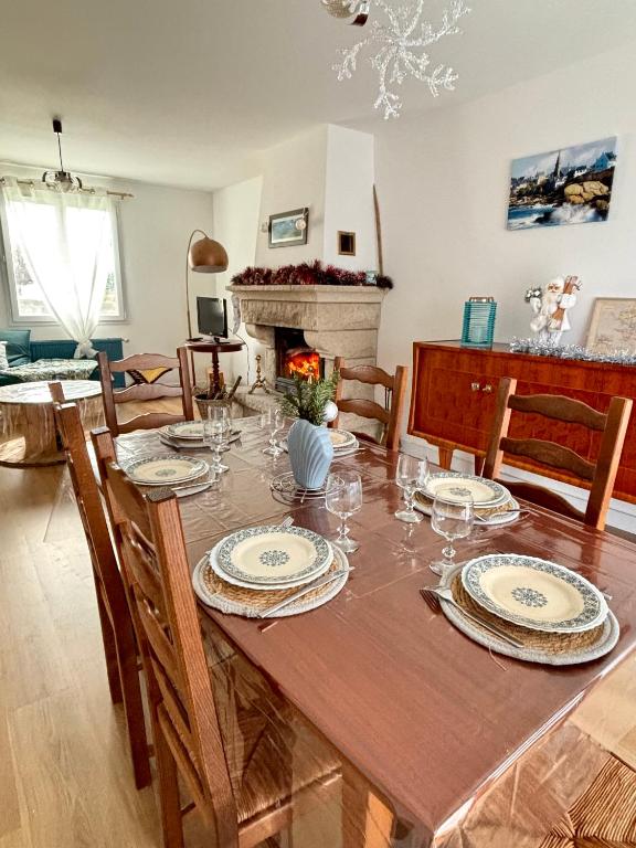 une salle à manger avec une table, des chaises et une cheminée dans l'établissement Maison idéale avec enfant, à Porspoder