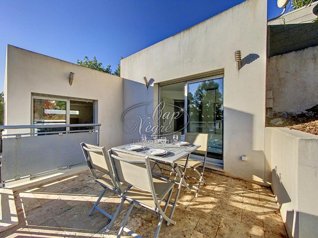 une table et des chaises sur le patio d'une maison dans l'établissement Maison moderne pour 4 personnes proche de la plage de Cavalière - Le Lavandou, au Lavandou