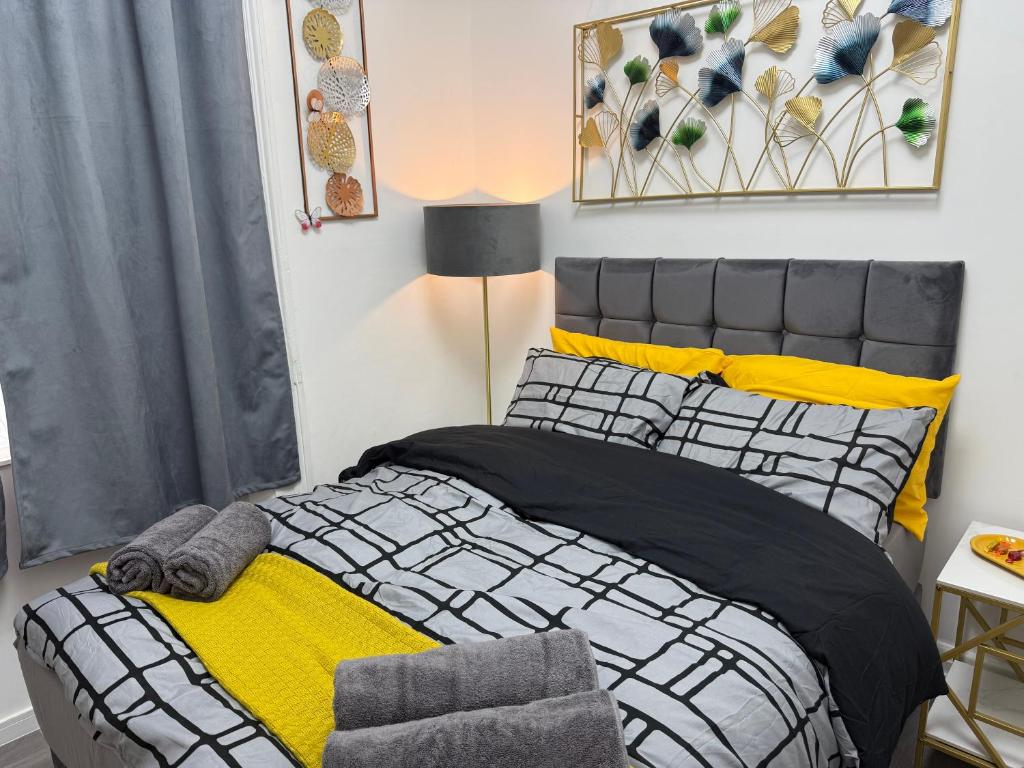 a bedroom with a bed with yellow and black at Luxury Studio in Victoria, 7 minutes walk to Victoria Station, Room 5 in London