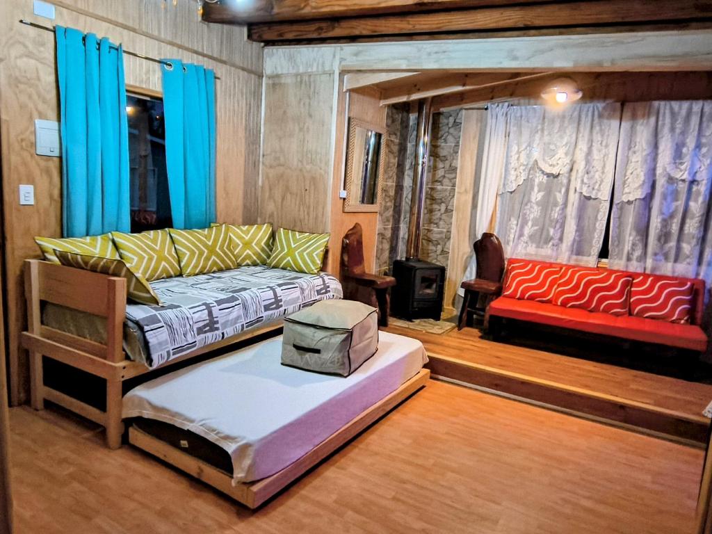 a living room with a couch and a red couch at Cabañas Lago Llanquihue in Llanquihue