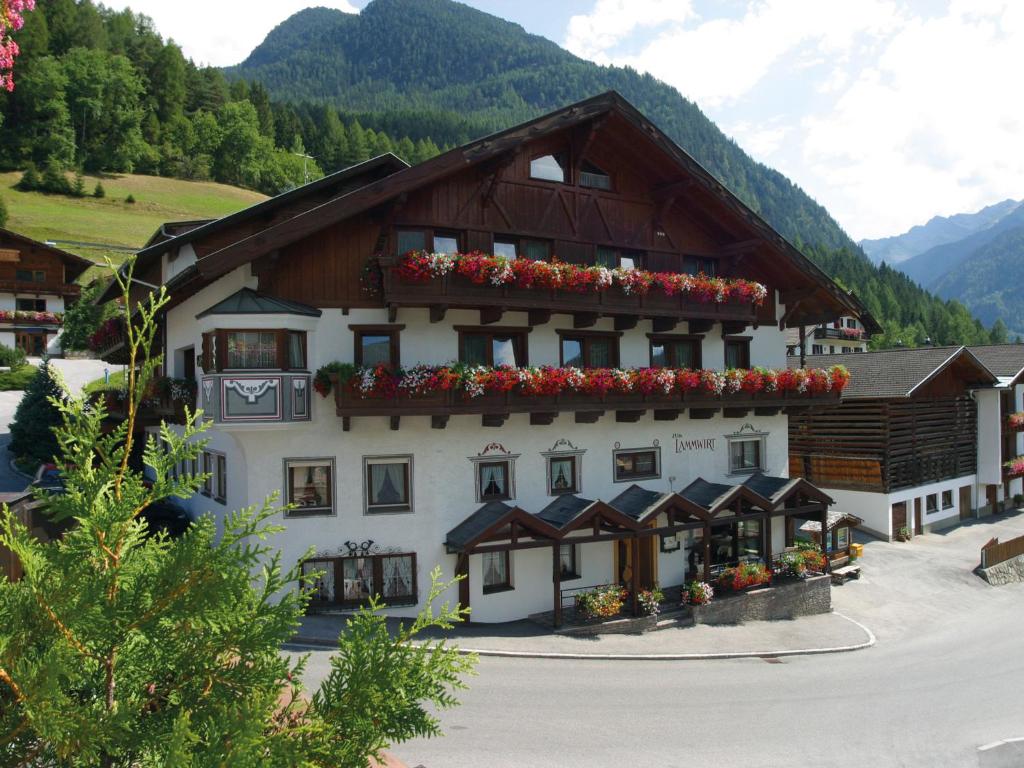 un gran edificio con flores en las ventanas en Hotel Lammwirt, en Jerzens