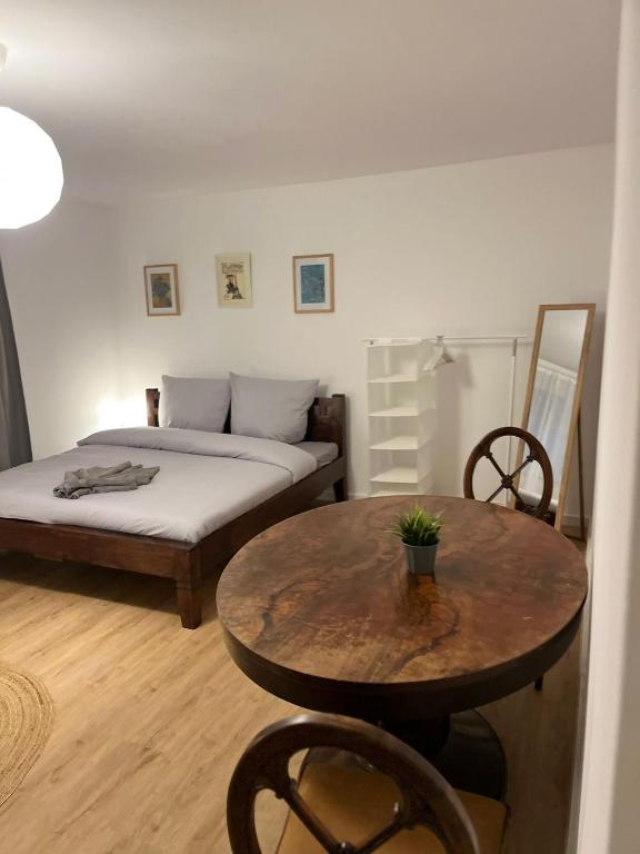 a bedroom with a table and a bed and a table and chairs at Süße Marie Durlach 13 in Karlsruhe