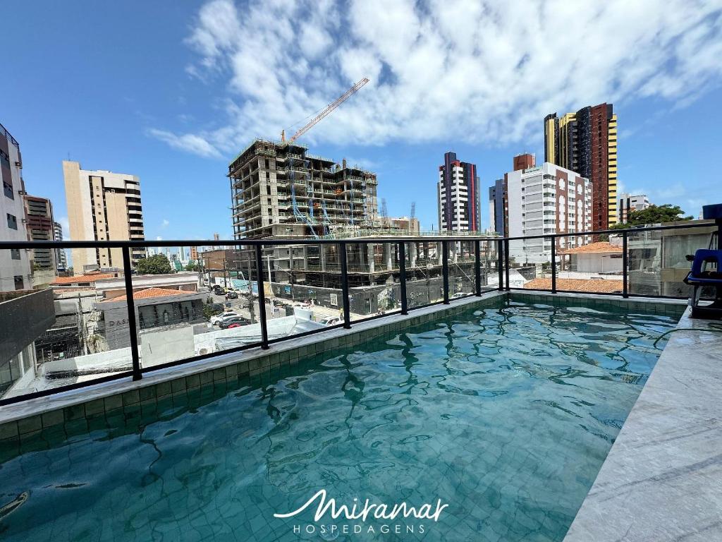 a swimming pool on the roof of a building at Simple Smart Residence in Tambaú