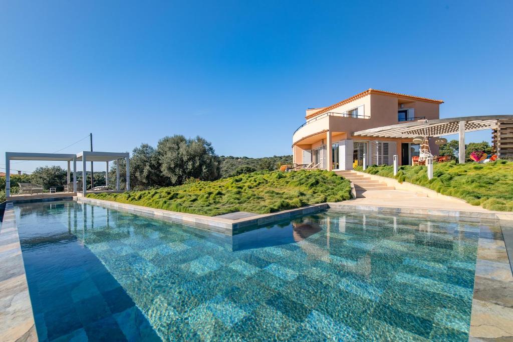 una piscina di fronte a un edificio di Villa La Ronde des Soleils a Coti-Chiavari