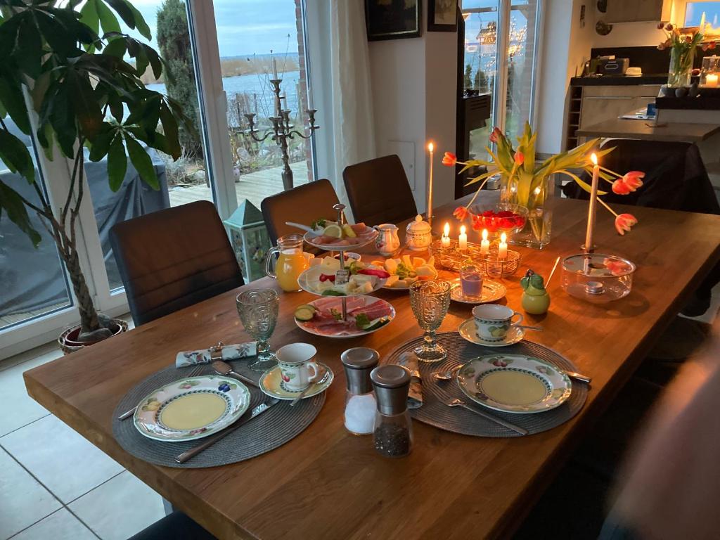 a wooden table with plates and candles on it at Auszeit am Haffufer in Wilhelmshof