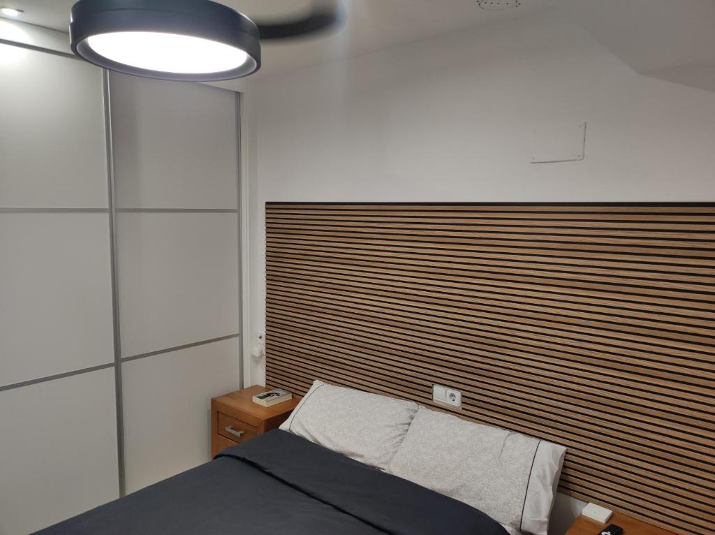 a bedroom with a bed and a large wooden headboard at el rincón de florida in Vigo