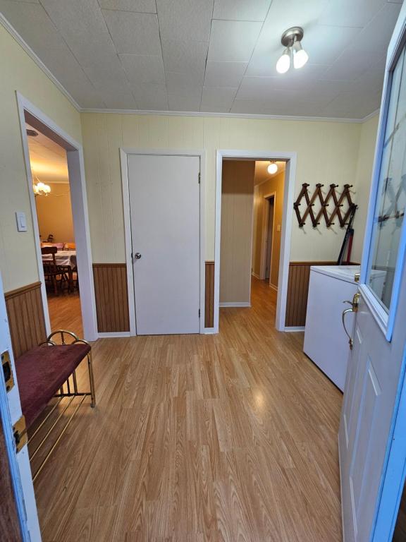 an empty room with a door and a table at Fair Isle Motel & The Nest in Whycocomagh