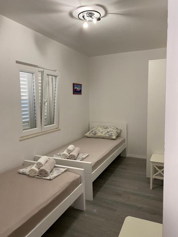 a room with two beds and a window at Apartments Štica- Pelješac in Janjina