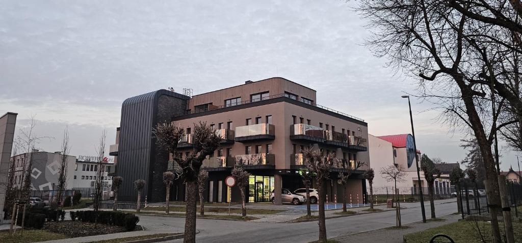a large building on a city street with trees at Penthouse in Nowy Sącz