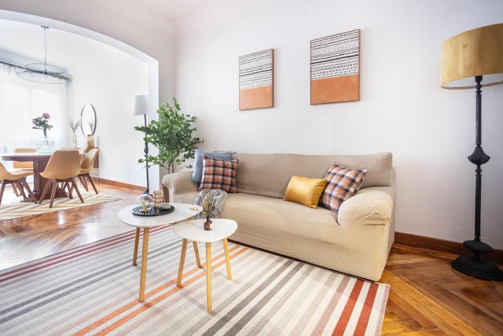 Una sala de estar con un sofá y dos mesas. en El Ñeru del Marqués - VUT5160AS, en Gijón