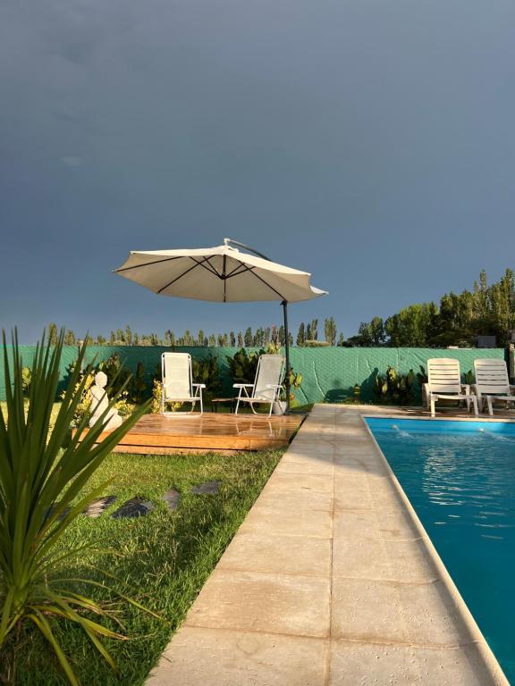 un patio con sombrilla y piscina en Departamento con Pileta camino a Cañon del Atuel San Isidro Pleno, en San Rafael
