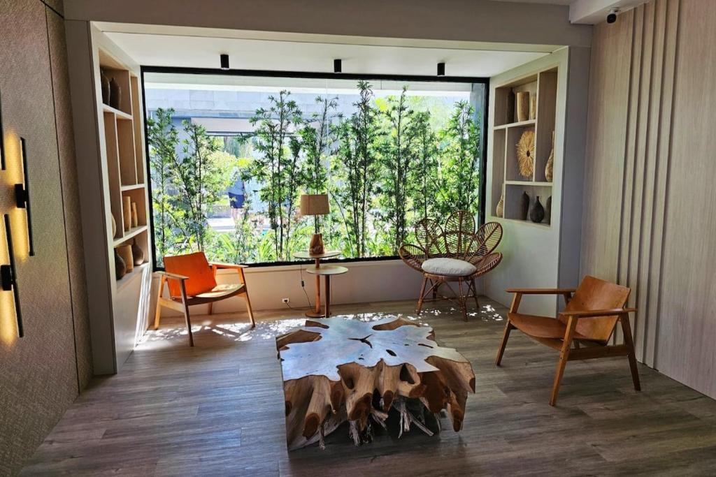 フロリアノポリスにあるCasa Vogue - Novo Campecheの大きな窓とテーブルのあるリビングルーム