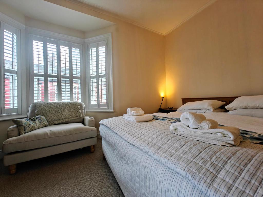 Hotel A beautiful home with charm and character, a bedroom with two beds and a chair and windows at A beautiful home with charm and character in Liverpool