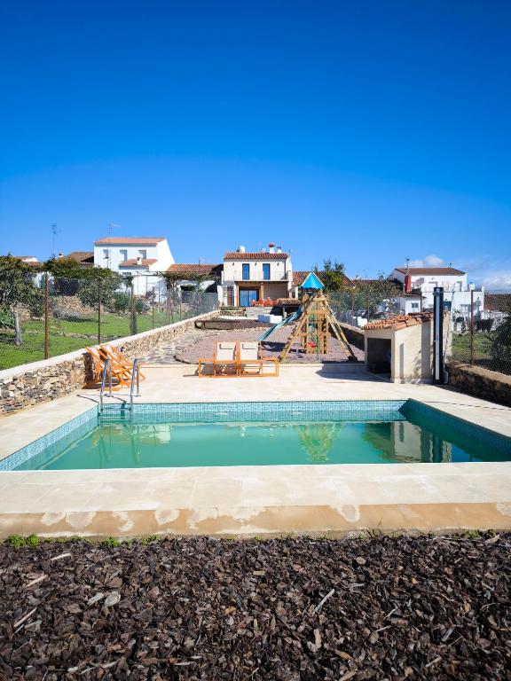 a swimming pool with a slide and a playground at fuerte trece in Encinasola