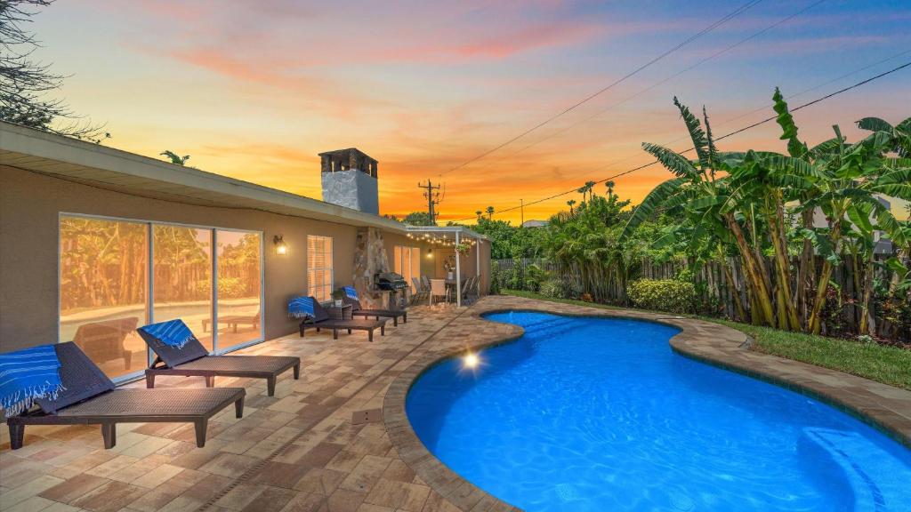 a swimming pool in a yard with chairs and a house at Paradise Palace in Sarasota