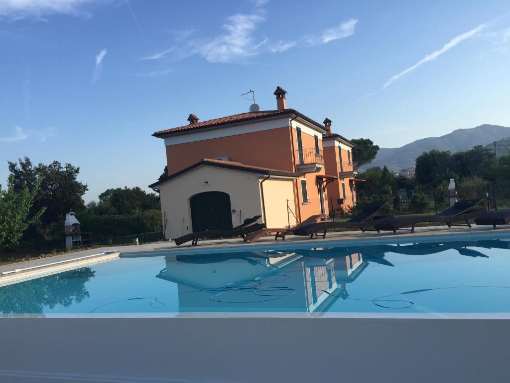 ein Haus mit einem Pool vor einem Gebäude in der Unterkunft Casa dei Girasoli in Castiglion Fiorentino