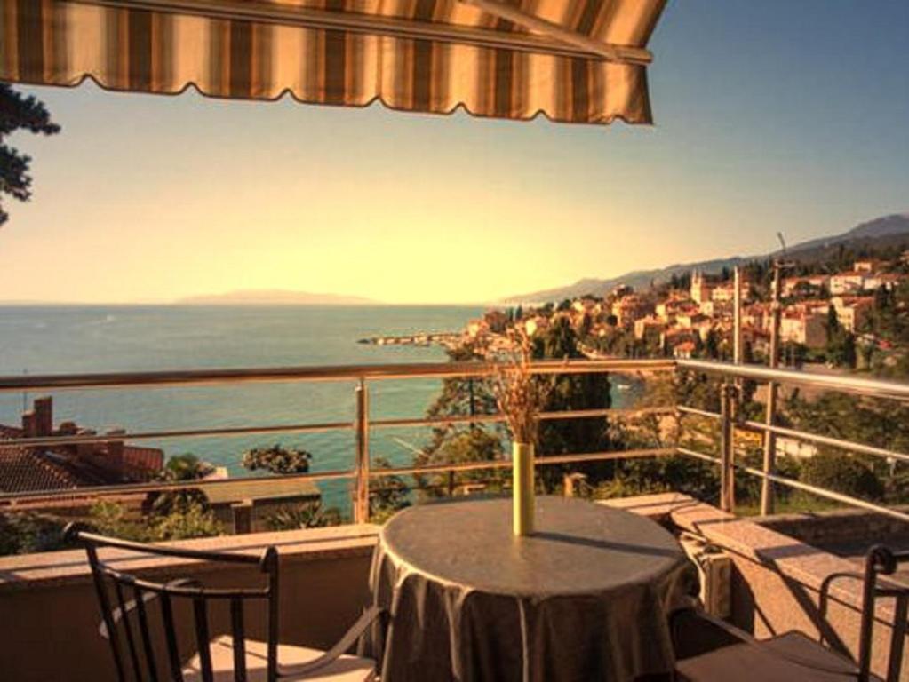 a table on a balcony with a view of the ocean at Apartments Villa Dinka in Opatija