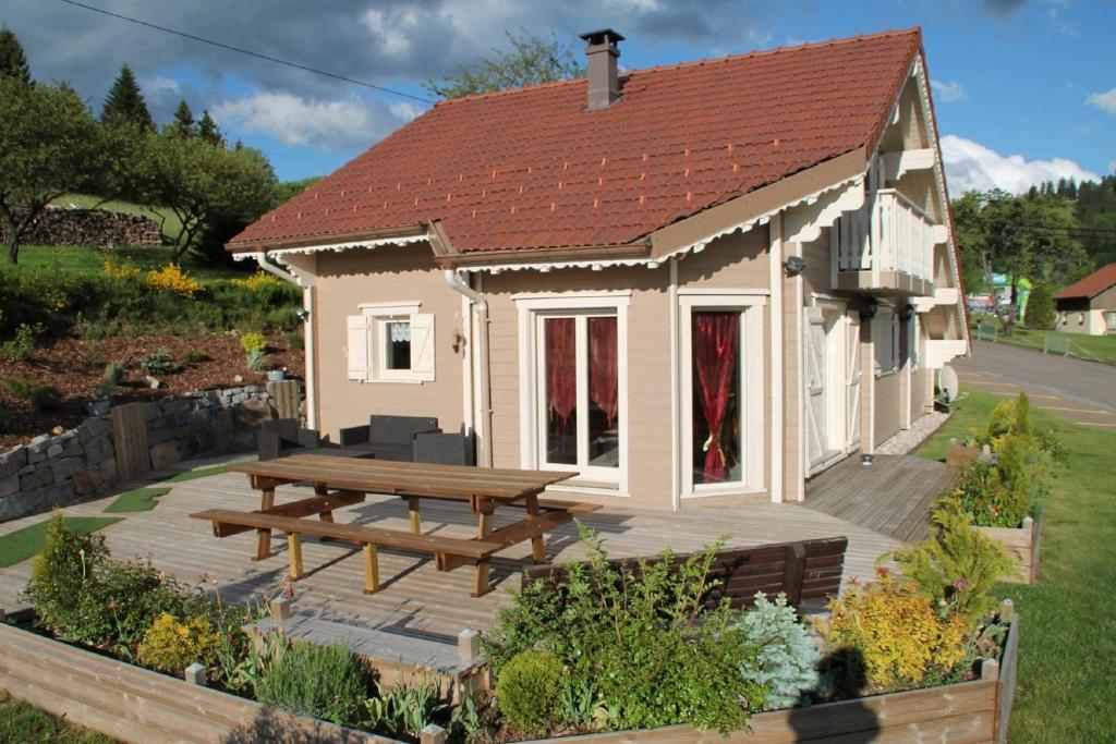 ジェラールメにあるChalet Le Roncingの木製デッキとピクニックテーブル付きの家