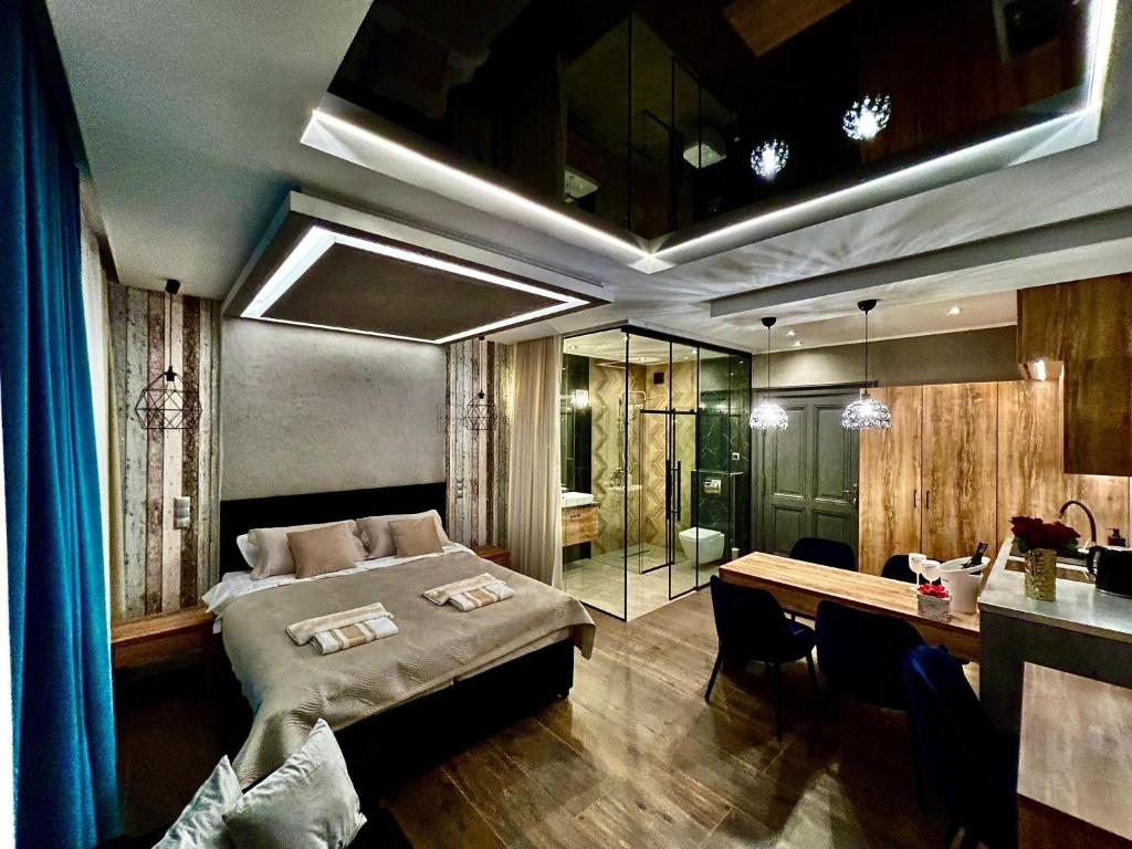 a bedroom with a bed and a desk and a table at Apartamenty Piernikowe in Toruń