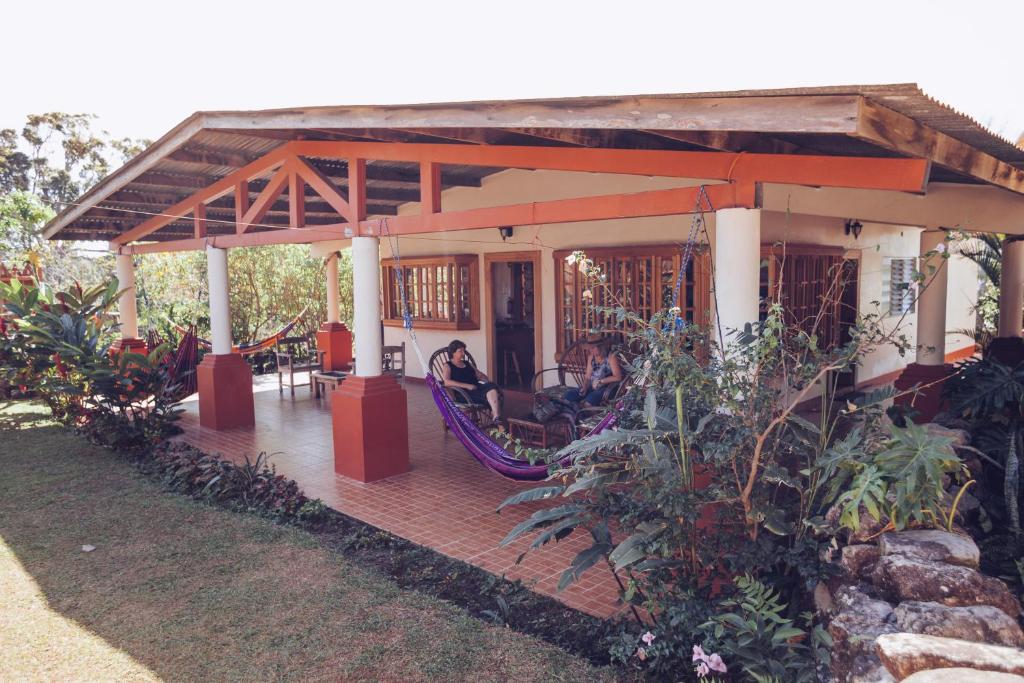 een huis met een veranda met een schommel bij Spanish by the River - Boquete in Boquete