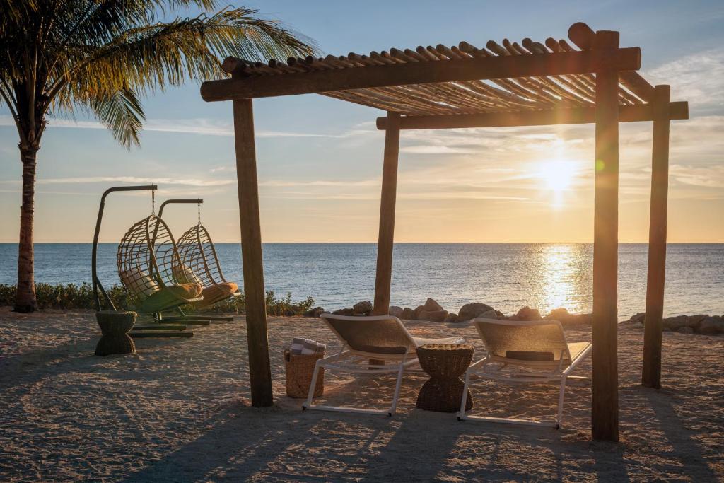 a playground on the beach with chairs and a swing at Islander Resort in Islamorada