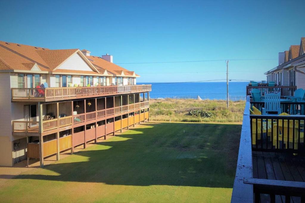 un balcone di un hotel con prato e oceano di Our guests love Waters Edge at Kitty Hawk 5 Stars a Kitty Hawk