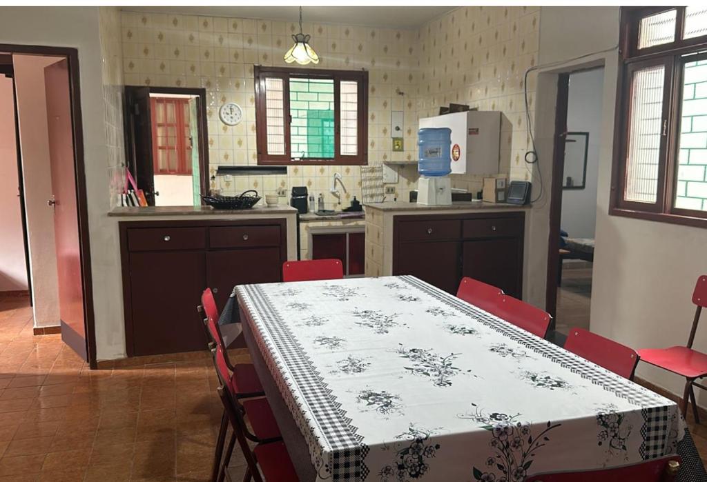 a kitchen with a table and red chairs and a kitchen with a table at Casa praia Guarapari in Guarapari