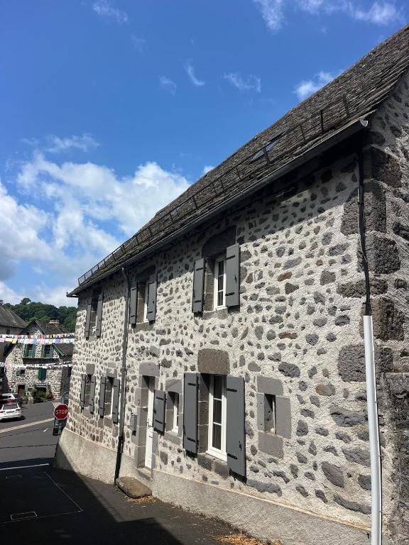 - un bâtiment en pierre avec des fenêtres sur le côté dans l'établissement Charmante maison de village, à Pierrefort