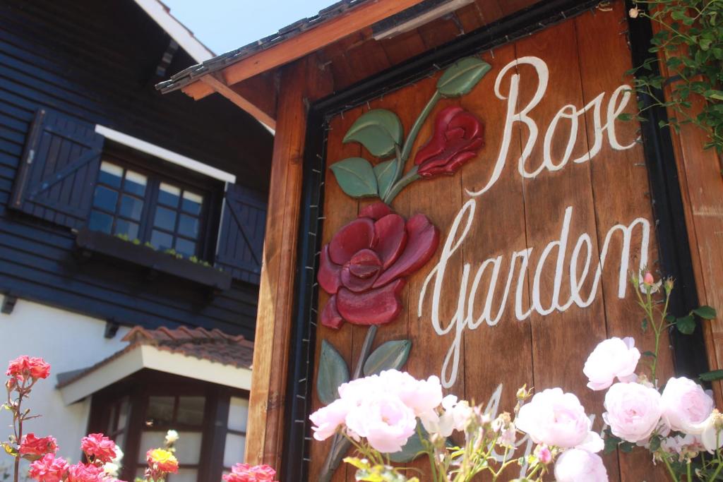 una señal en el lado de un edificio con flores en Apart Rose Garden en San Martín de los Andes