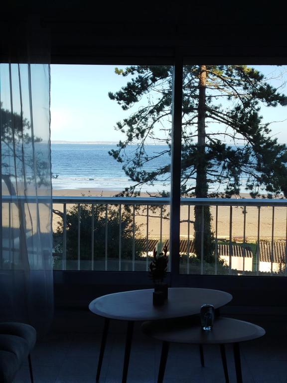 Cette chambre dispose d'une table et offre une vue sur la plage. dans l'établissement La Baie en direct du Balcon !, à Douarnenez