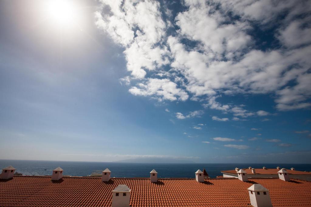 um telhado de um edifício com o oceano ao fundo em Residencial Playa de La Arena em Puerto de Santiago