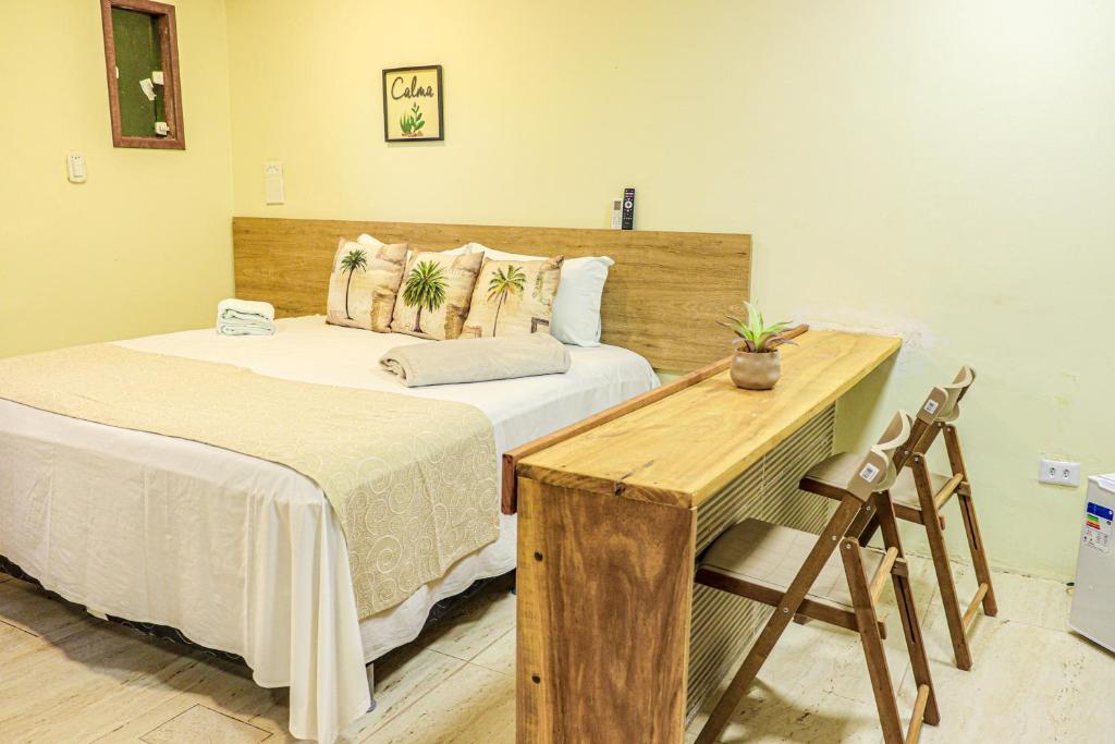 ein Schlafzimmer mit zwei Betten und einem Holzschreibtisch in der Unterkunft Pousada kanoas suites in São José da Coroa Grande