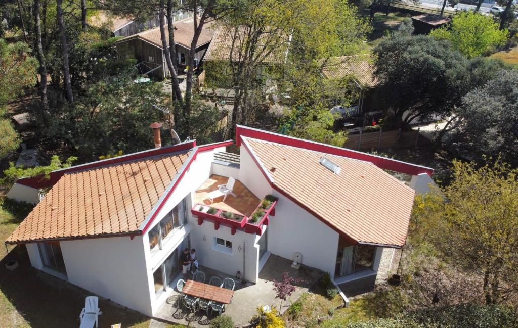 une vue aérienne sur une maison blanche avec un toit rouge dans l'établissement Villa Amapola, familiale et calme, à Lacanau