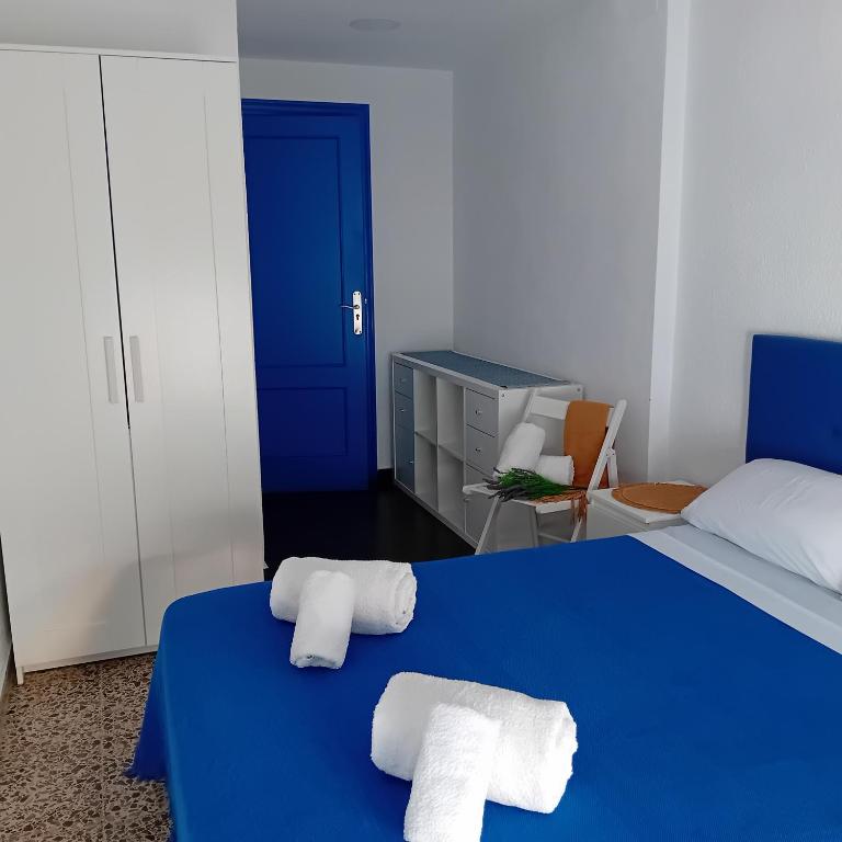 a bedroom with two towels on a blue bed at María PLAYA 1 NG in Peniscola