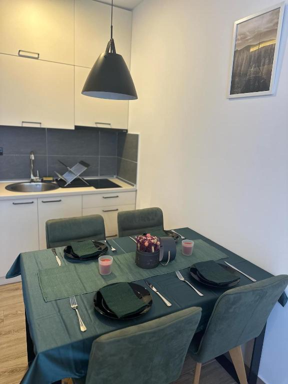 a dining room table with a green table cloth at Apartman B64 Residence Hill Kopaonik in Kopaonik