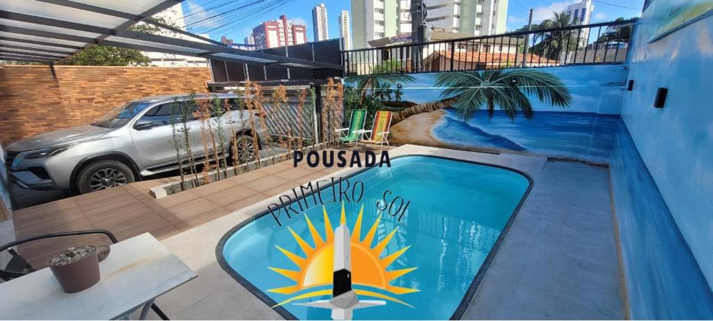 una piscina con un cartello sul lato di un edificio di Pousada Primeiro Sol a João Pessoa