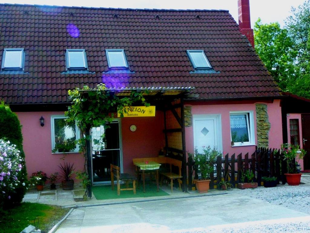 une maison rose avec une table devant elle dans l'établissement Private Světluška, à Poběžovice