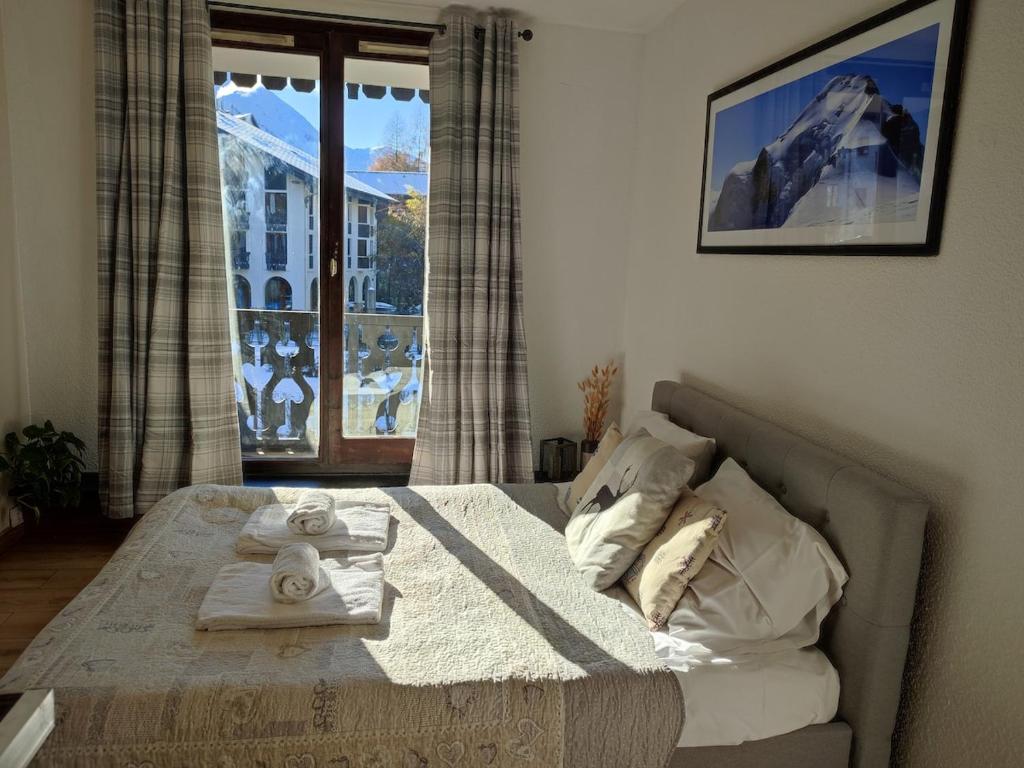 une chambre avec un lit et une grande fenêtre dans l'établissement Cozy Alpine Studio, à Chamonix-Mont-Blanc